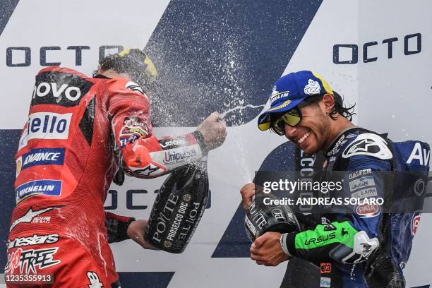 Race winner Ducati Italian rider Francesco Bagnaia and third-placed Ducati-Avintia Italian rider Enea Bastianini spray Prosecco wine as they...