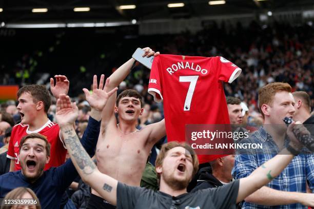 Manchester United's fans celebrate with a shirt of Manchester United's Portuguese striker Cristiano Ronaldo in the crowd after the English Premier...