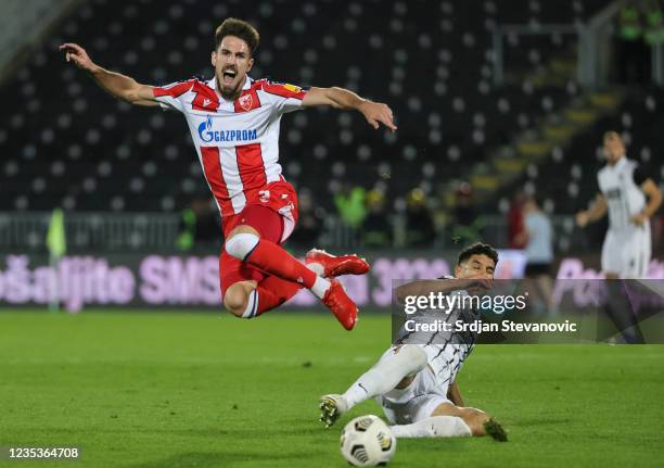 Milos Degenek of Crvena Zvezda is challenged by Aleksandar Miljkovic of Partizan during the Serbian Super Liga match between FK Partizan and FK...