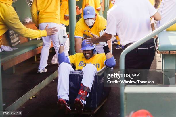 Martinez of the Boston Red Sox gets a ride in the laundry cart after hitting a home run against the Baltimore Orioles during the third inning at...
