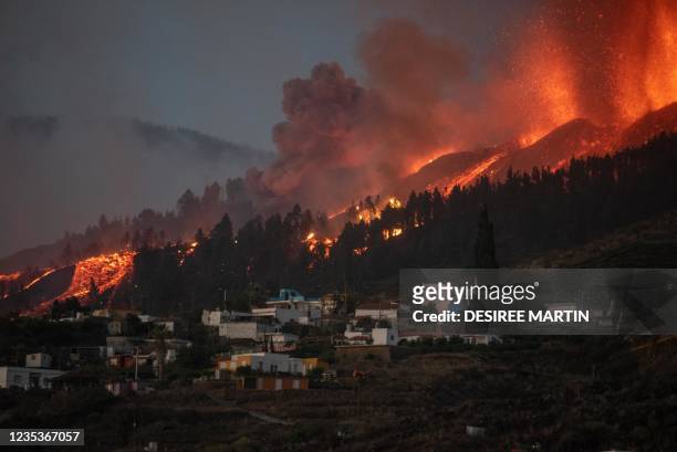 River of lava approaches houses as Mount Cumbre Vieja erupts in El Paso, spewing out columns of smoke, ash and lava as seen from Los Llanos de...