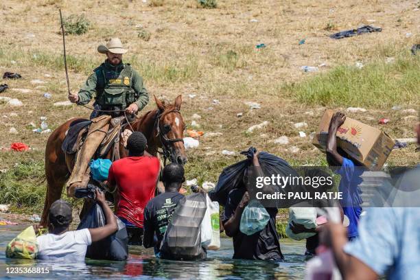 United States Border Patrol agent on horseback uses the reins as he tries to stop Haitian migrants from entering an encampment on the banks of the...