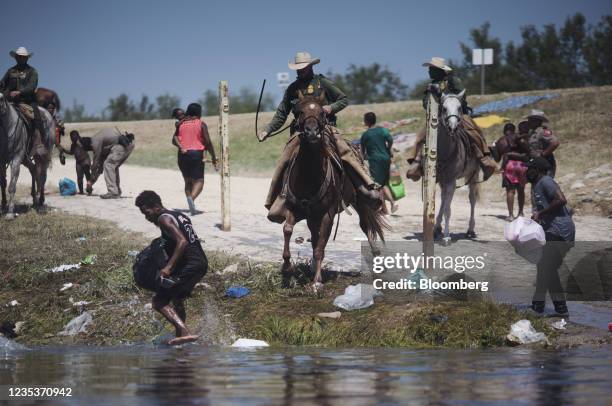 Border Patrol agents stop migrants crossing the Rio Grande River near the Del Rio-Acuna Port of Entry in Del Rio, Texas, U.S., on Sunday, Sept. 19,...