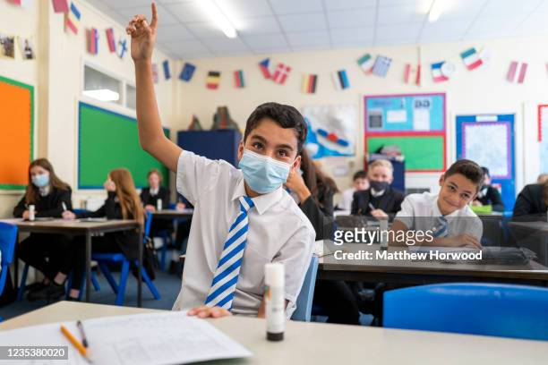 Child raises his hand in a geography class at Llanishen High School on September 20, 2021 in Cardiff, Wales. All children aged 12 to 15 across the UK...