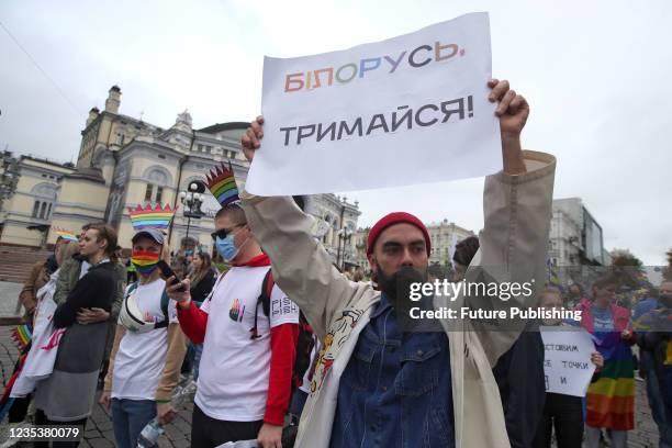 Demonstrator holds a placard 'Belarus, Holds On' on Volodymyrska Street near the National Opera House during the Equality March carried out in...