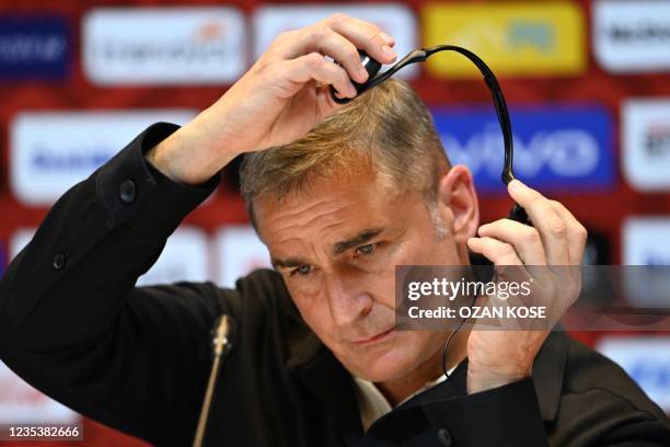 Turkey national football team's newly appointed, German head coach Stefan Kuntz, adjusts his headphones as he attends a signing ceremony at Turkish...