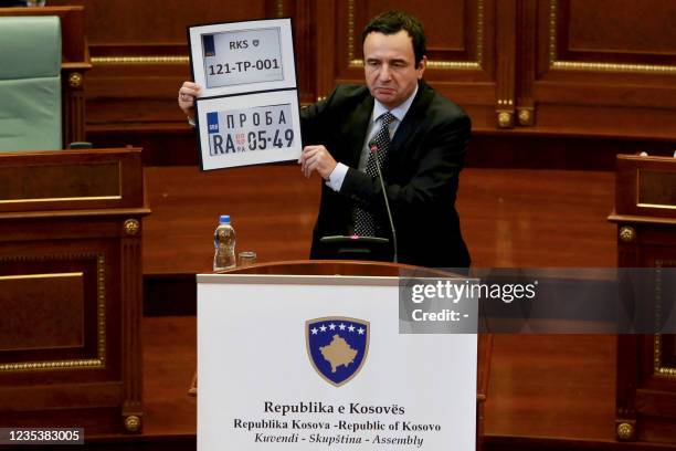 Kosovo Prime Minister Albin Kurti shows Kosovo and Serbia temporary car plates during a parliament session in Pristina on September 20, 2021. -...