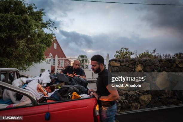 People leave their homes as Mount Cumbre Vieja continues to erupt in El Paso, spewing out columns of smoke, ash and lava as seen from Los Llanos de...