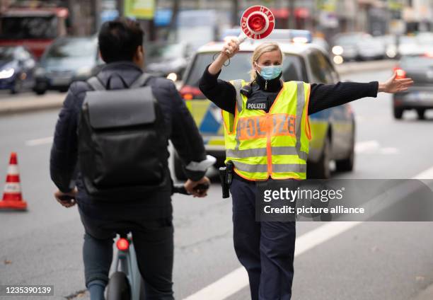 September 2021, Hessen, Frankfurt/Main: A policewoman stops a cyclist. With a focus control in the city centre, the officers were mainly on the trail...