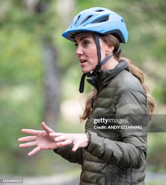 Britain's Catherine, Duchess of Cambridge, reacts as she wears a mountain biking helmet as she visits Royal Air Force Air Cadets at their Windermere...