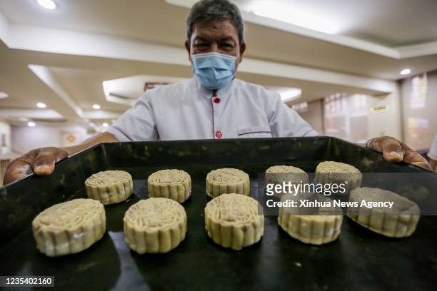 Chef shows a tray of mooncakes to be baked at a Chinese restaurant in Chinatown in Manila, the Philippines, Sept. 17, 2021. The Mid-Autumn Festival...