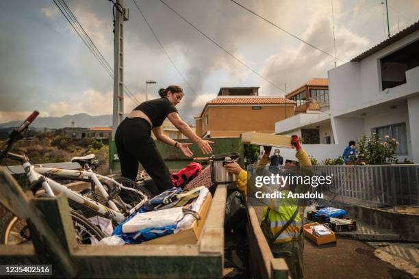 Officials help during an evacuation process as Mount Cumbre Vieja continues to erupt in El Paso, spewing out columns of smoke, ash and lava on the...