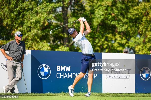 Justin Thomas plays a shot as his father Mike Thomas looks on during practice for the BMW Championship, the second event of the FedExCup Playoffs, at...
