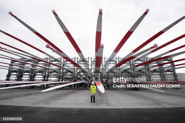 General Electric employee stands front of wind turbine blades for the construction of a wind farm off Saint-Nazaire, in Saint-Nazaire, western...