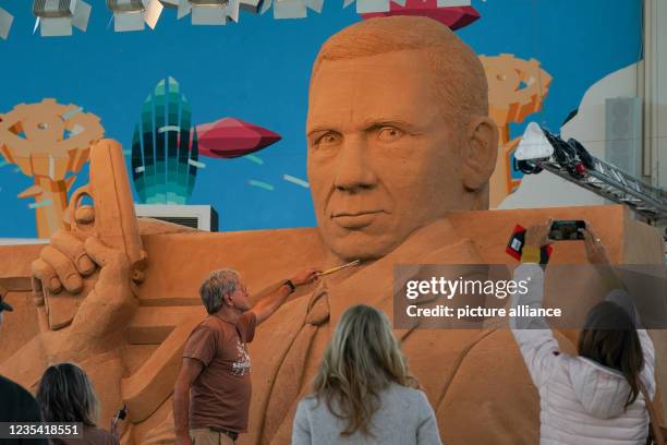 September 2021, Saxony-Anhalt, Weißenfels: Artist Benno Lindel is putting the finishing touches to his sand sculpture on the theme of "James Bond" in...