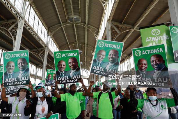 Action South Africa supporters carry posters showing the face of their leader Herman Mashaba and City of Tshwane mayoral candidate Abel Tau during...