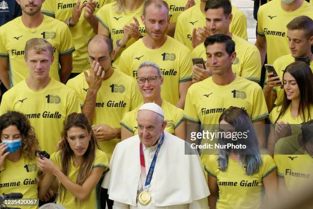 Pope Francis poses for a photo wearing an Olympic gold medal as he salutes Paralympic and Olympic athletes attending his weekly general audience in...