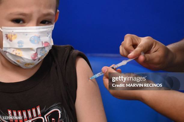 Child receives a dose of the Sinopharm Covid-19 vaccine at El Salvador's main vaccination center in San Salvador, on September 22, 2021.