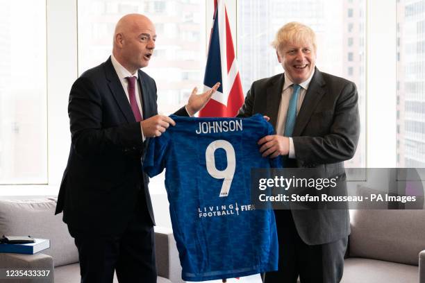 Prime Minister Boris Johnson is given a football shirt by FIFA President, Gianni Infantino before their meeting in New York during the Prime...