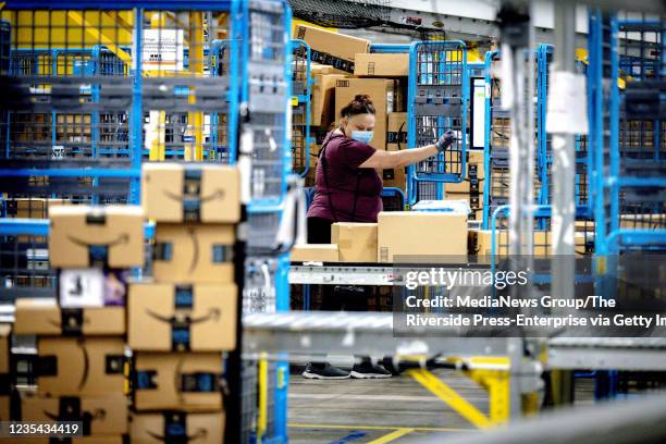 Worker sorts out packages in the outbound dock at Amazon fulfillment center in Eastvale on Tuesday, Aug. 31, 2021.