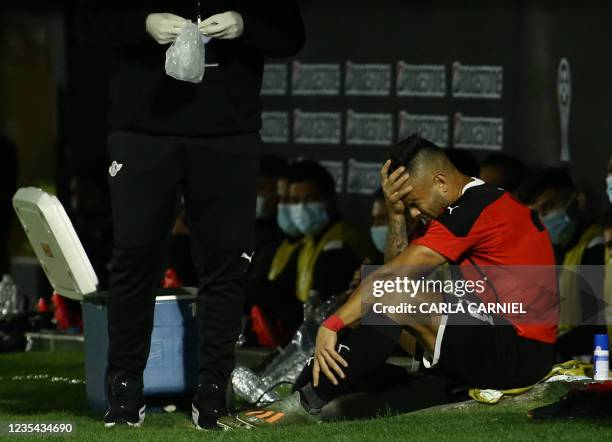 Paraguay's Libertad Hector Villalba gestures in pain after being injured during the Copa Sudamericana semi-final first leg football match against...