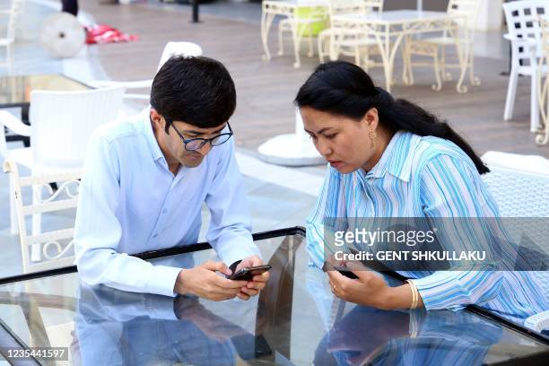 Elyas Nawandish, an Afghan journalist, and his wife Latifa Frotan, chat in a bar outside a tourist resort in the coastal city of Shengjin on...