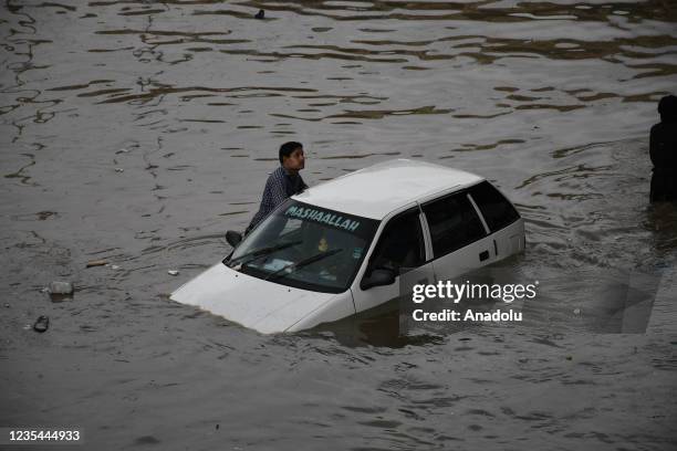 Commuters struggle to move forward in a flooded street after heavy monsoon rains in Pakistan's port city of Karachi on September 23, 2021.