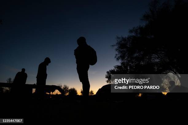 Haitian migrants are seen near the Rio Grande river in Ciudad Acuna, Coahuila state, Mexico, on September 23, 2021. - At least 50 police vehicles...