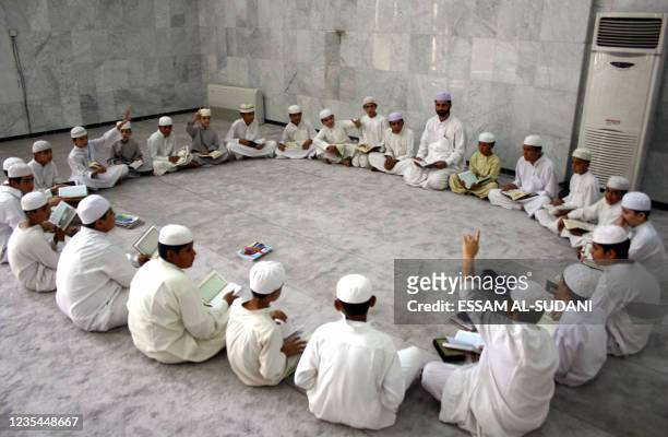 Muslim boys take part in a lesson at the Madrassa or school attached to a local mosque in the southern city of Basra, some 500 kms from Baghdad, 16...