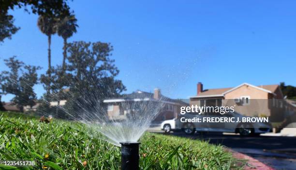 Sprinkler waters grass in Alhambra, California on September 23, 2021. - Water usage in Southern California has increased since July when Governor...