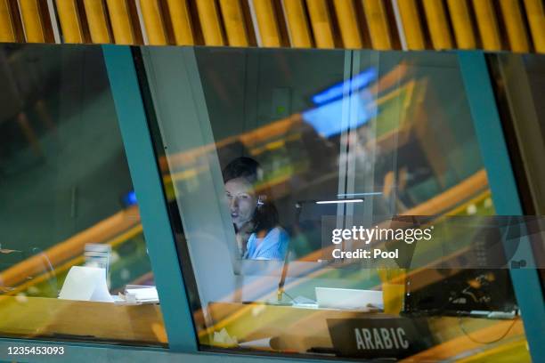Delegates are seen reflected in the window as a translator works in her booth as a head of state addresses the 76th Session of the U.N. General...