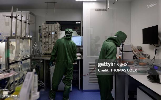 Lab technicians work on a process machine to produce CAR-T cells and RNA in the laboratory of French biopharmaceutical company Cellectis in Paris on...