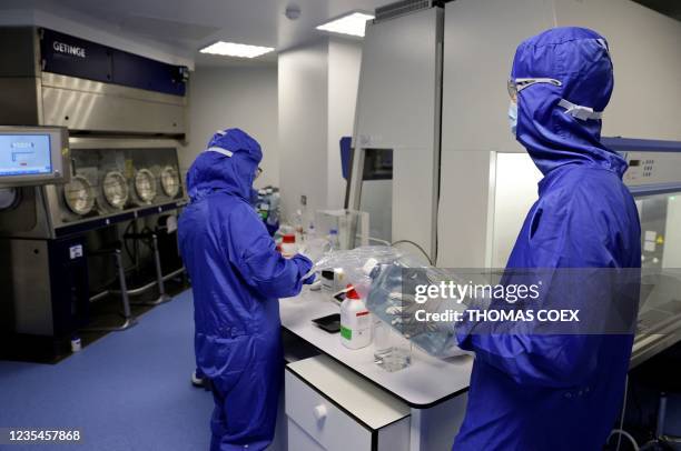 Lab technicians work on a process machine to produce CAR-T cells and RNA in the laboratory of French biopharmaceutical company Cellectis in Paris on...