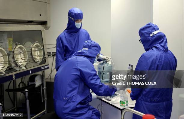 Lab technicians work on a process machine to produce CAR-T cells and RNA in the laboratory of French biopharmaceutical company Cellectis in Paris on...