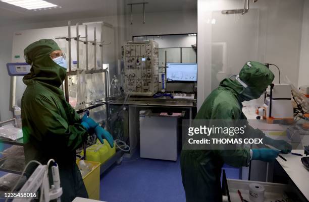 Lab technicians work on a process machine to produce CAR-T cells and RNA in the laboratory of French biopharmaceutical company Cellectis in Paris on...