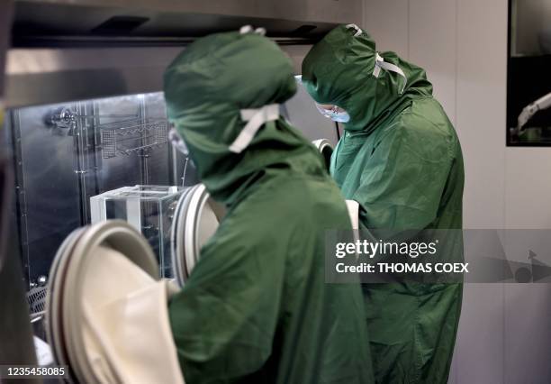 Lab technicians work on a process machine to produce CAR-T cells and RNA in the laboratory of French biopharmaceutical company Cellectis in Paris on...