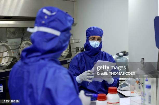 Lab technicians work on a process machine to produce CAR-T cells and RNA in the laboratory of French biopharmaceutical company Cellectis in Paris on...