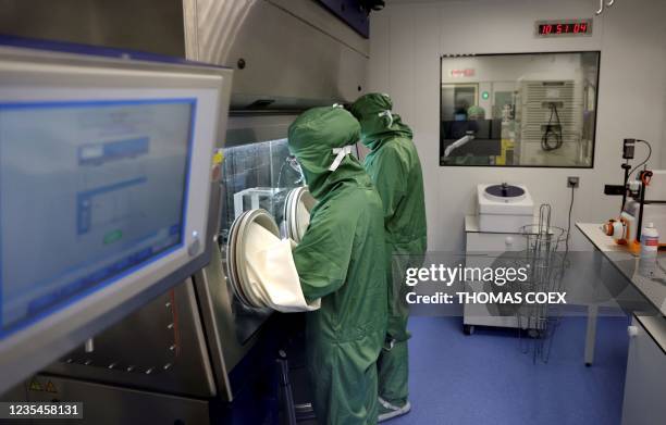 Lab technicians work on a process machine to produce CAR-T cells and RNA in the laboratory of French biopharmaceutical company Cellectis in Paris on...