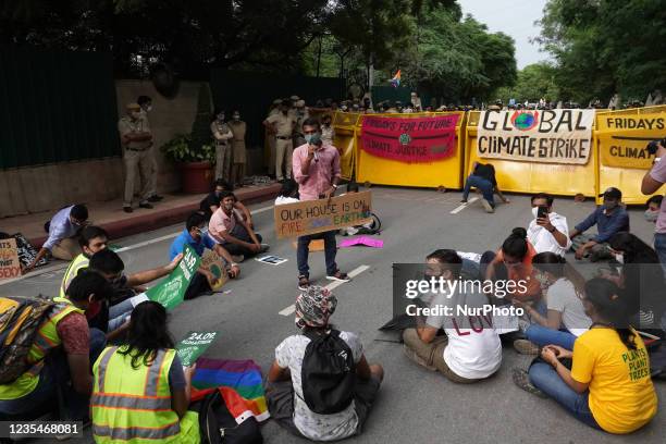 Protester holding a placard addresses others as they participate in a march during a global climate strike as part of the 'Fridays for Future'...