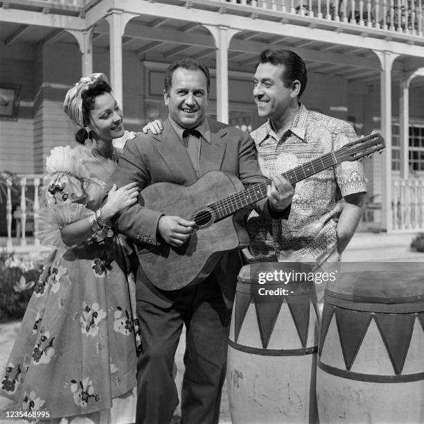 French composer Francis Lopez poses with Spanish singer Luis Mariano and Spanish singer and dancer Paquita Rico on October 4, 1956 in the studios of...