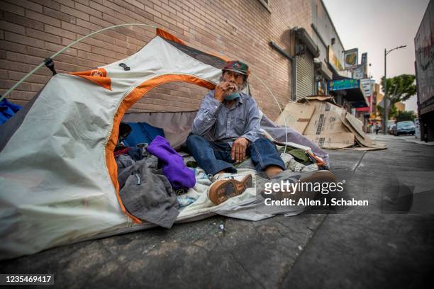 Los Angeles, CA Bobby Rojas who has been homeless four years, smokes in his tent amidst a homeless encampment on Skid Row Thursday, Sept. 23, 2021 in...