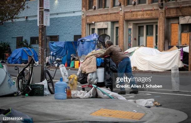 Los Angeles, CA A person pushes a cart of their belongings through a homeless encampment on Skid Row Thursday, Sept. 23, 2021 in Los Angeles, CA. A...