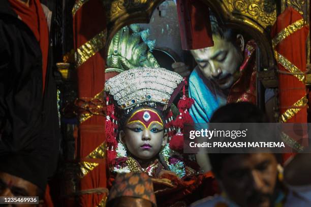 Girl revered as a living goddess or Kumari is carried in a chariot during a procession on the last day of the Indra Jatra festival at Basantapur...