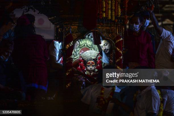 Girl revered as a living goddess or Kumari is carried in a chariot during a procession on the last day of the Indra Jatra festival at Basantapur...
