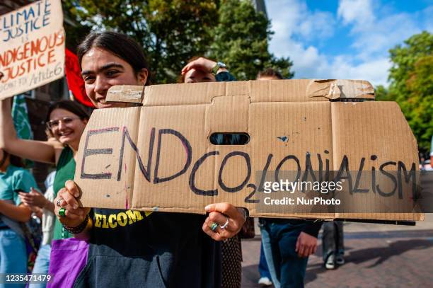 Woman is holding a placard against colonialism, during the Global Climate Strike organized in Utrecht, on September 24th, 2021.