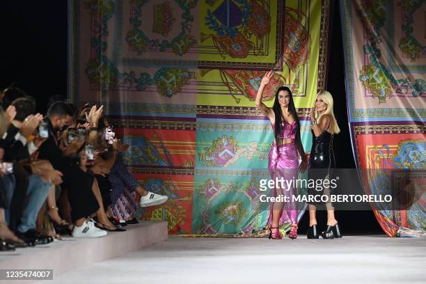British singer and model Dua Lipa and Italian fashion designer Donatella Versace acknowledge applause following the presentation of Versace's Women's...