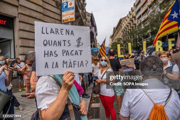 Protester holds a placard accusing Spanish Judge Pablo Llarena of paying the mafia in exchange for favors during the demonstration. Hundreds of...