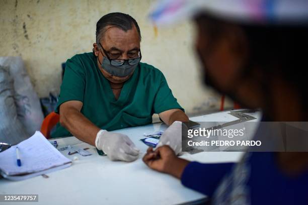 Doctor tests a Haitian migrant for HIV and syphilis at the Terraza Fandango shelter in Ciudad Acuna, Coahuila state, Mexico, on September 24, 2021. -...