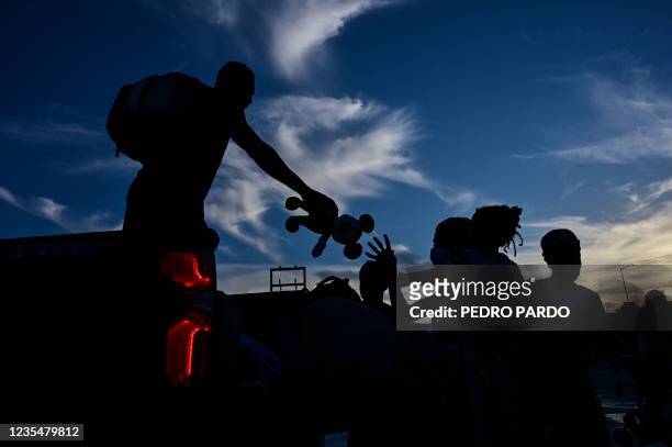 Haitian migrants get off a truck as they arrive at the Terraza Fandango shelter after leaving a makeshift camp in the Braulio Mendoza Park in Ciudad...