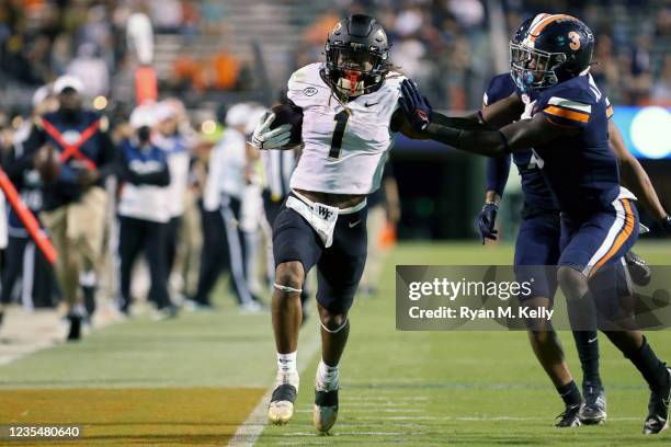 Anthony Johnson of the Virginia Cavaliers pushes Christian Beal-Smith of the Wake Forest Demon Deacons out of bounds in the second half during a game...
